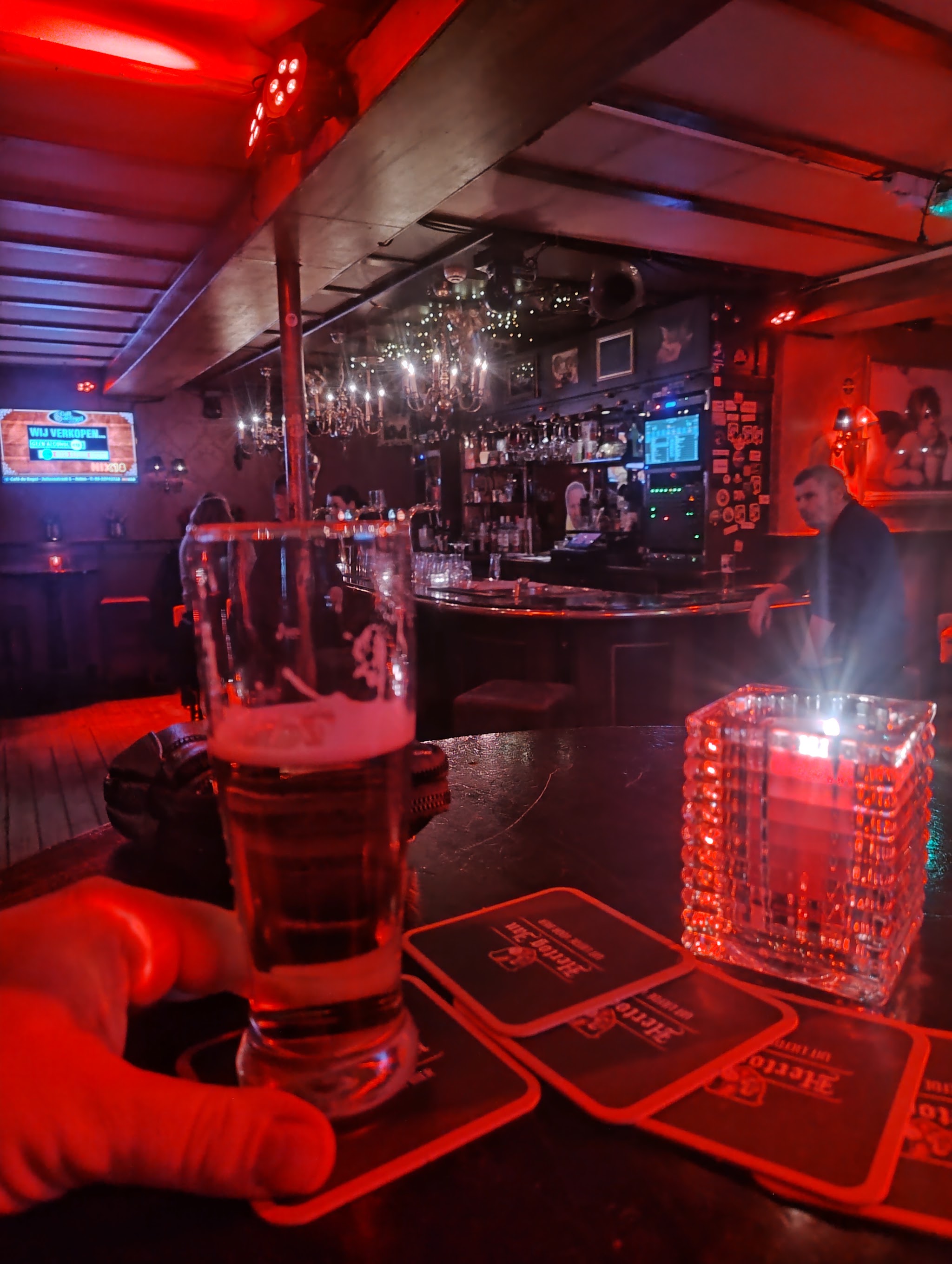 Een biertje op de bar van Café de Engel in het rode avondlicht