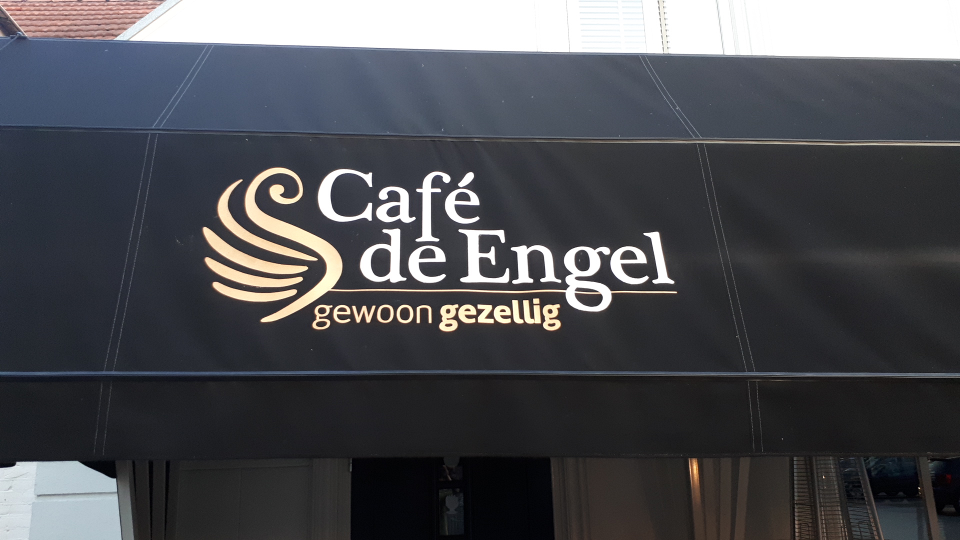 De luifel van Café de Engel met het gouden logo en de tekst gewoon gezellig