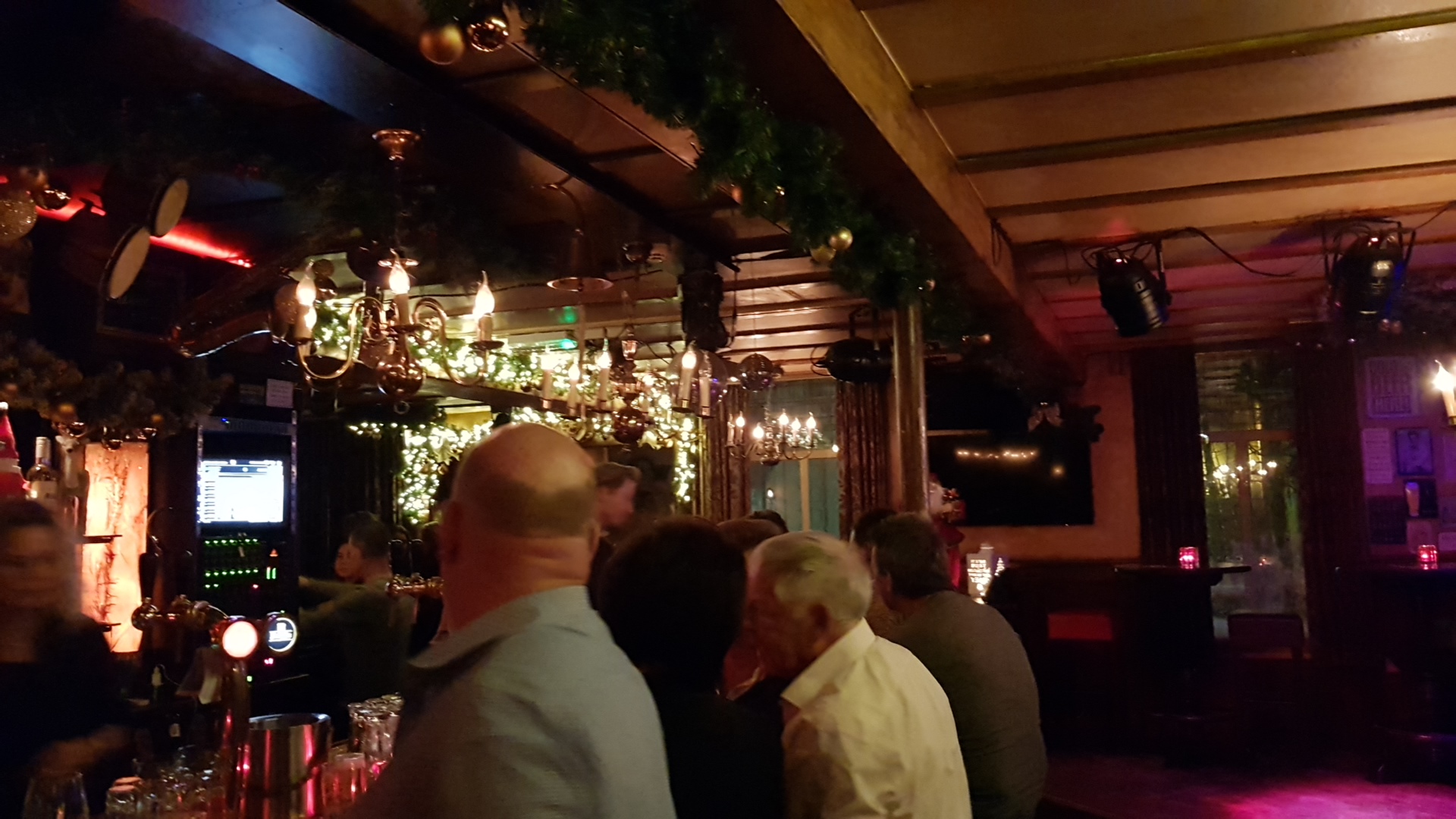 Een drukke avond aan de bar onder de kroonluchters